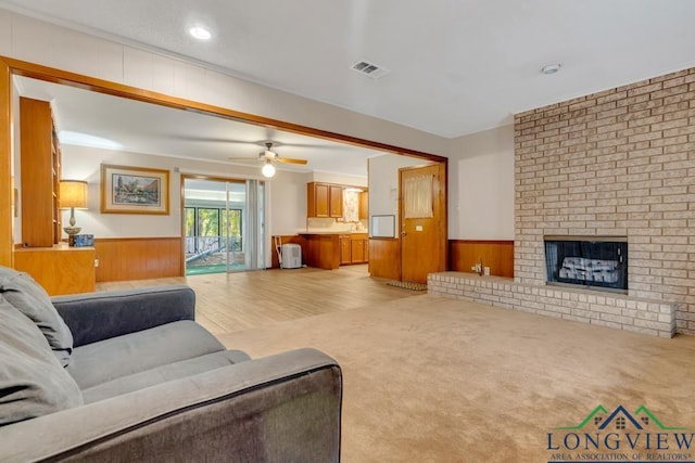 carpeted living room featuring a fireplace, ceiling fan, and sink