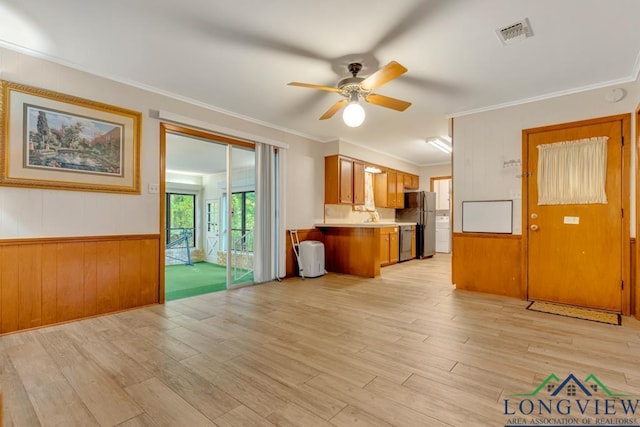 kitchen with kitchen peninsula, appliances with stainless steel finishes, ceiling fan, crown molding, and light hardwood / wood-style floors