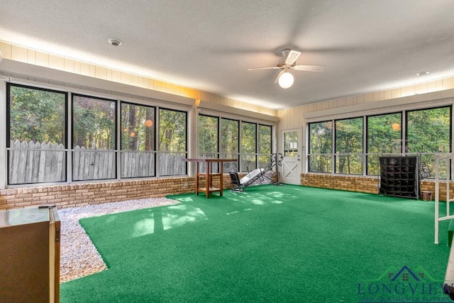 unfurnished sunroom with ceiling fan and plenty of natural light