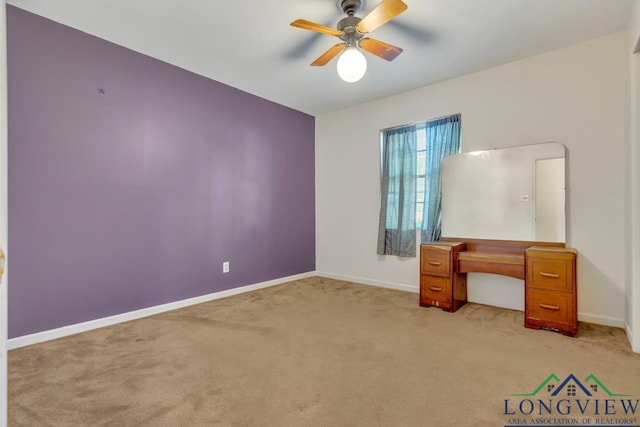 unfurnished office with ceiling fan and light colored carpet