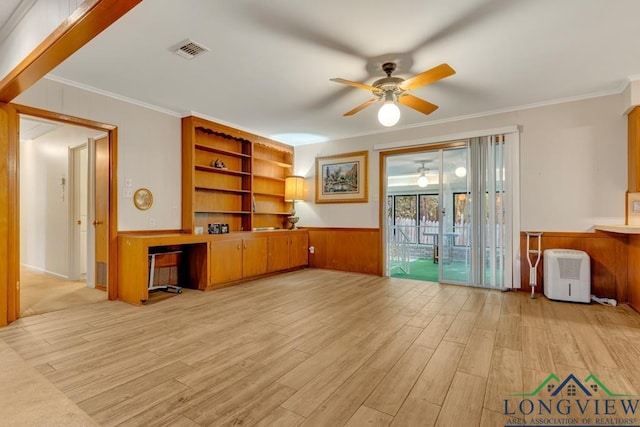 unfurnished living room featuring crown molding, light hardwood / wood-style flooring, ceiling fan, and wood walls