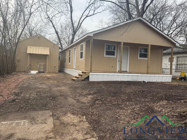 view of front of house with a porch and an outdoor structure