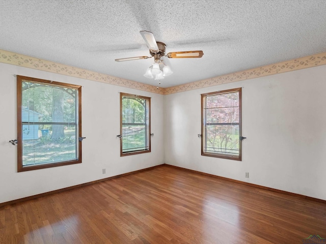 spare room featuring hardwood / wood-style floors, a textured ceiling, plenty of natural light, and ceiling fan