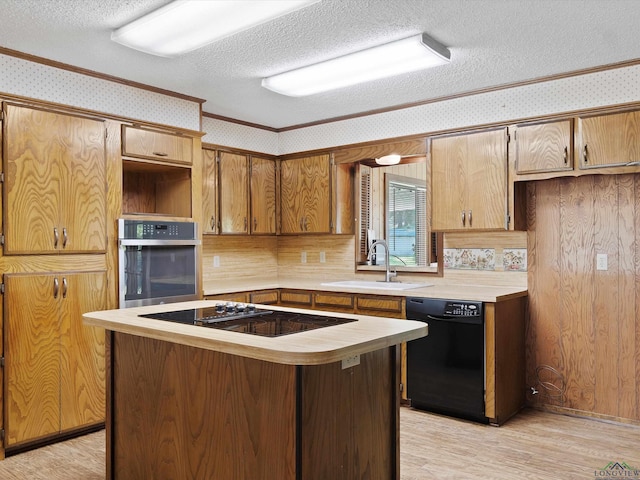 kitchen featuring a textured ceiling, sink, ornamental molding, and black appliances