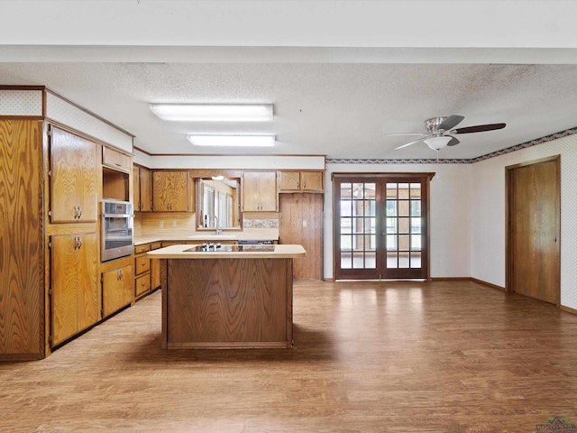 kitchen featuring tasteful backsplash, stainless steel oven, french doors, and a textured ceiling