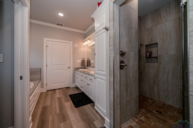 bathroom with hardwood / wood-style floors, vanity, crown molding, and plus walk in shower