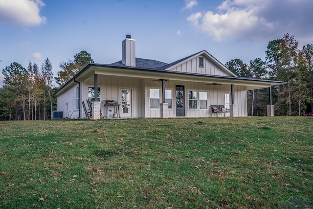 back of house featuring central AC, ceiling fan, and a yard