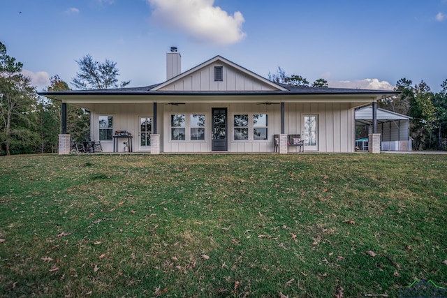 rear view of property featuring a yard and a carport