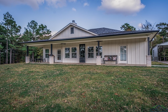 view of front of house featuring ceiling fan, a front lawn, and covered porch