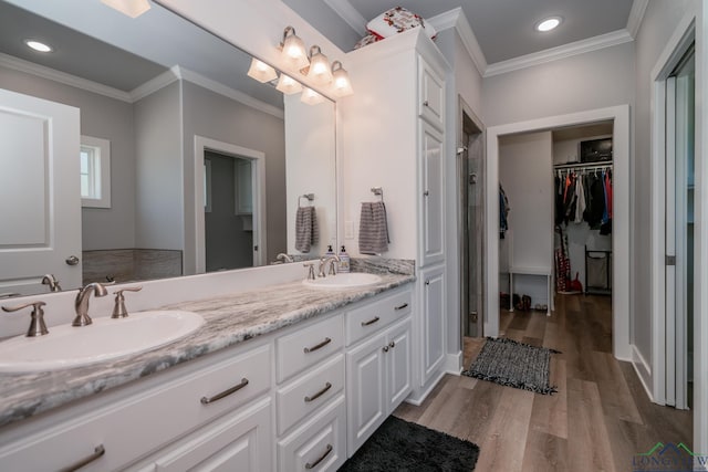 bathroom with wood-type flooring, vanity, and crown molding