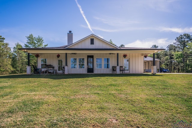 back of house with ceiling fan and a yard