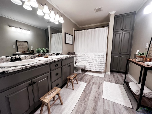 full bath with toilet, wood finished floors, a sink, visible vents, and ornamental molding