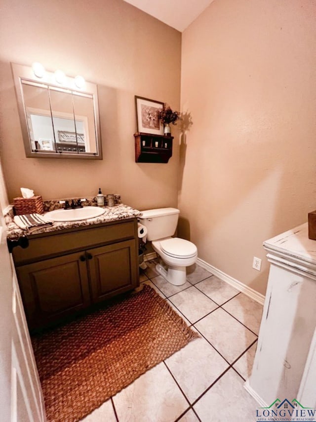 bathroom with vanity, tile patterned flooring, toilet, and baseboards