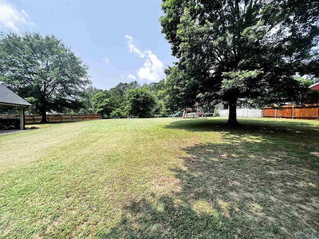 view of yard with a playground and fence