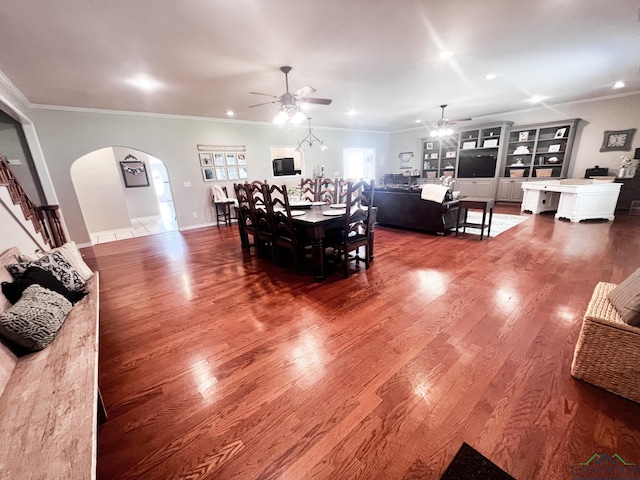 dining room with arched walkways, a ceiling fan, wood finished floors, crown molding, and recessed lighting