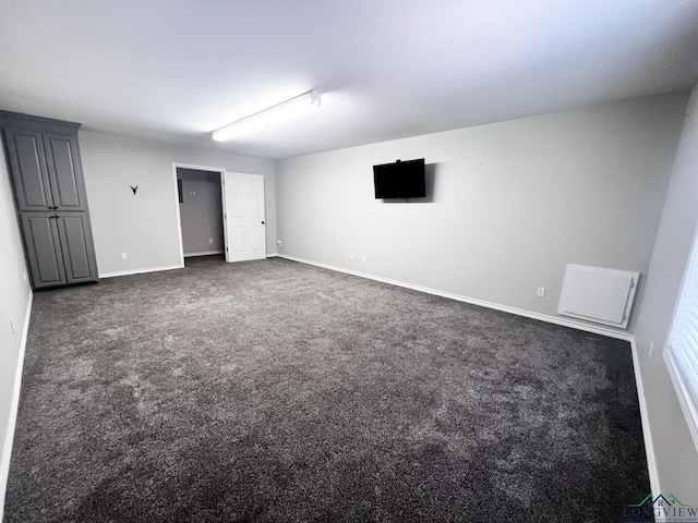 unfurnished bedroom featuring dark colored carpet and baseboards