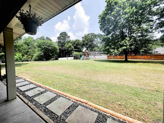 view of yard featuring fence and a playground