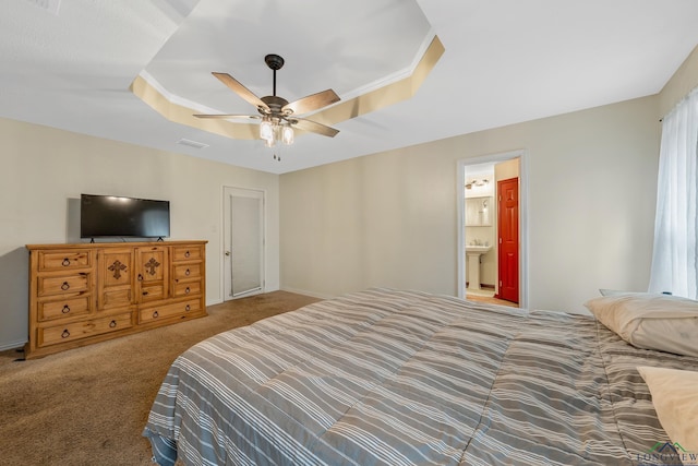 bedroom with visible vents, a sink, a tray ceiling, carpet flooring, and ceiling fan