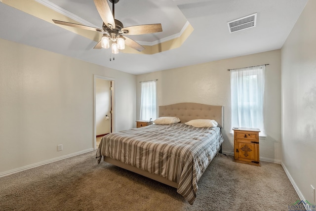 bedroom with a tray ceiling, visible vents, carpet floors, and baseboards