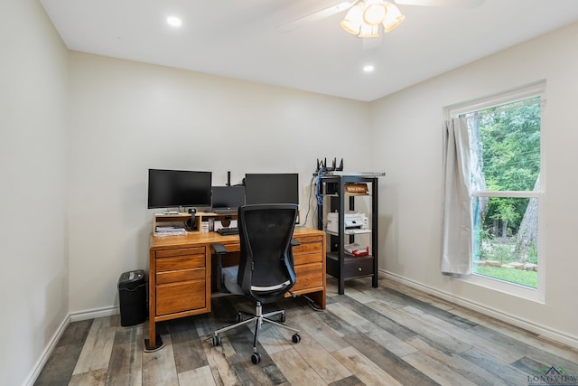 office space with a wealth of natural light, light wood-type flooring, and baseboards