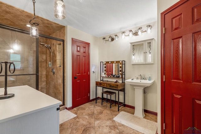 bathroom with tile patterned floors, a shower stall, baseboards, and a sink