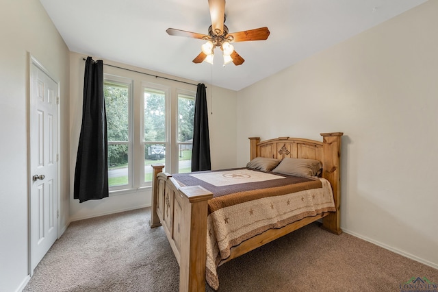 bedroom with a ceiling fan, light colored carpet, and baseboards