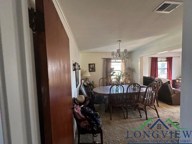 729 Rosehill Rd, Timpson, TX 75975 - carpeted dining room with a chandelier