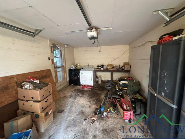 729 Rosehill Rd, Timpson, TX 75975 - garage featuring independent washer and dryer and a garage door opener