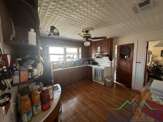 729 Rosehill Rd, Timpson, TX 75975 - kitchen featuring range, ceiling fan, light countertops, dark wood-style flooring, and range hood