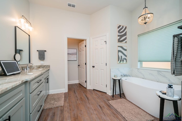 4523 Lone Oak Ln, Longview, TX 75605 - bathroom with a freestanding bath, wood finished floors, vanity, and a chandelier