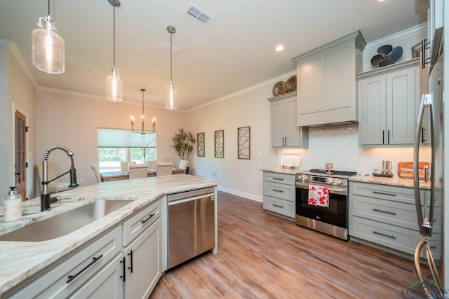 4523 Lone Oak Ln, Longview, TX 75605 - kitchen featuring appliances with stainless steel finishes, ornamental molding, gray cabinetry, light wood-style floors, and light stone countertops