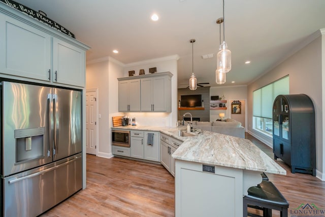 4523 Lone Oak Ln, Longview, TX 75605 - kitchen with stainless steel appliances, a peninsula, open floor plan, ornamental molding, and a kitchen bar