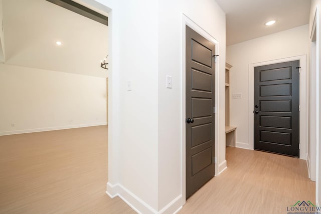 corridor featuring light wood-style floors, baseboards, and recessed lighting