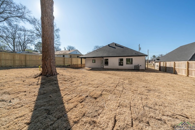 back of house with central air condition unit, a fenced backyard, and a shingled roof