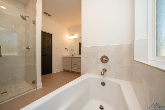 full bath featuring a garden tub, visible vents, a shower stall, and vanity