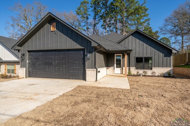 modern farmhouse style home with concrete driveway, roof with shingles, an attached garage, board and batten siding, and brick siding