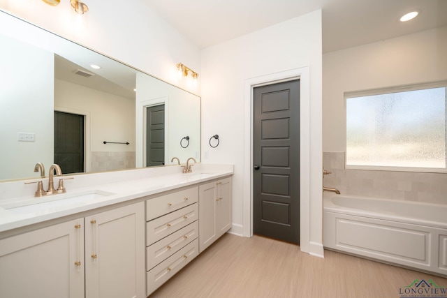 full bathroom with wood finished floors, visible vents, a sink, and double vanity