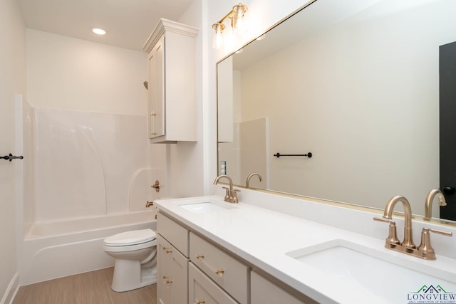 full bathroom with toilet, double vanity, a sink, and shower / bathing tub combination