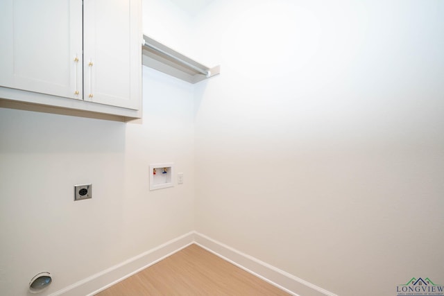 clothes washing area with hookup for a washing machine, baseboards, light wood-style floors, cabinet space, and electric dryer hookup