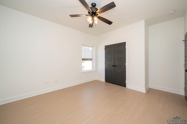 spare room featuring ceiling fan, baseboards, and wood finished floors