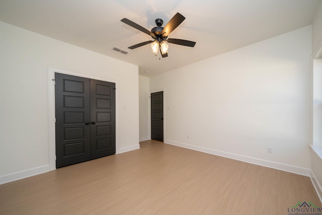 spare room featuring light wood-style flooring, visible vents, and baseboards