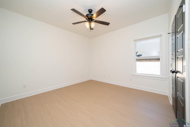 unfurnished room featuring light wood-type flooring, a ceiling fan, and baseboards