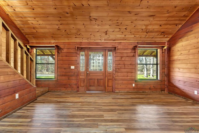 entryway featuring wood walls, wooden ceiling, hardwood / wood-style floors, and lofted ceiling