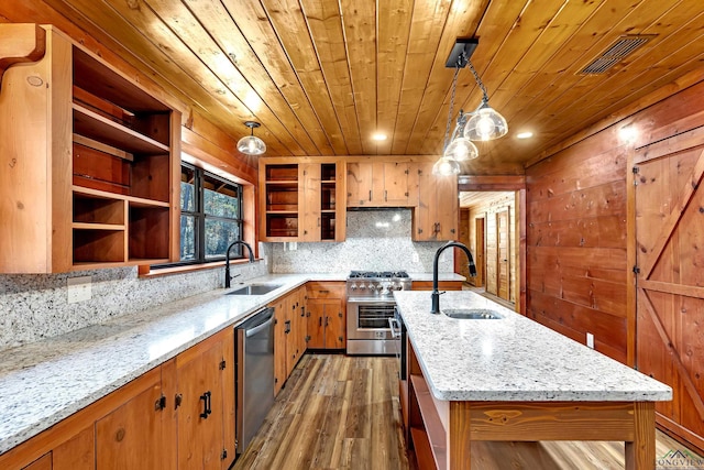 kitchen with dark hardwood / wood-style floors, appliances with stainless steel finishes, sink, and pendant lighting