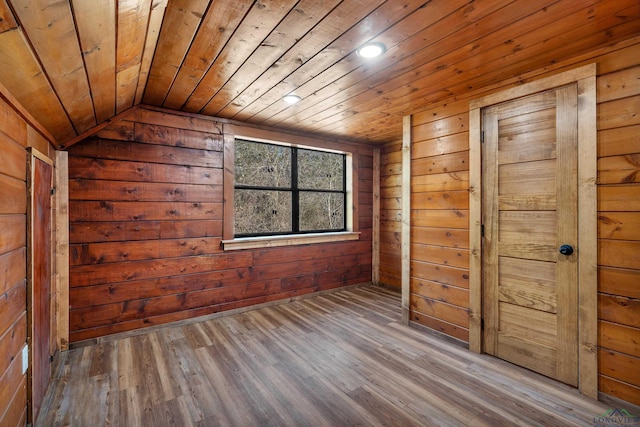 unfurnished bedroom with vaulted ceiling, wooden ceiling, and wood walls