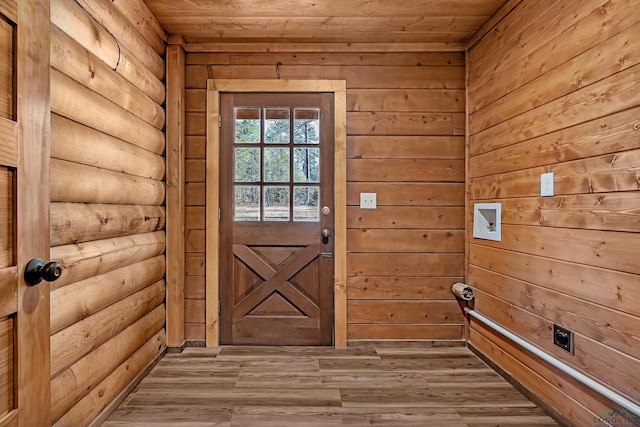 entryway with wooden ceiling, rustic walls, wood walls, and light wood-type flooring