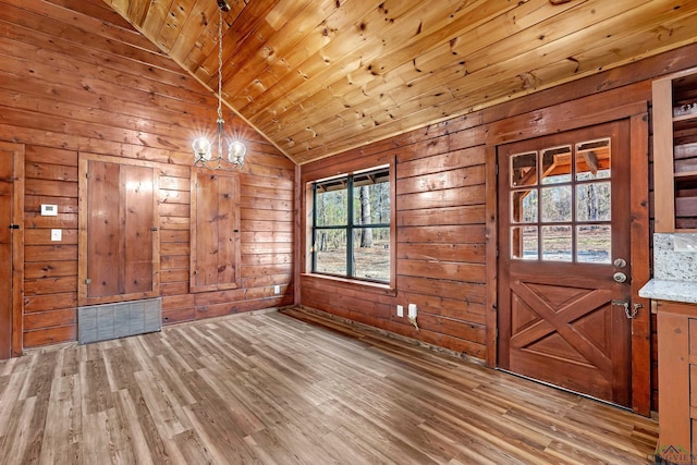 entryway featuring lofted ceiling, hardwood / wood-style floors, an inviting chandelier, wooden walls, and wooden ceiling