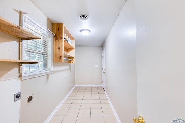 clothes washing area with electric dryer hookup and light tile patterned floors