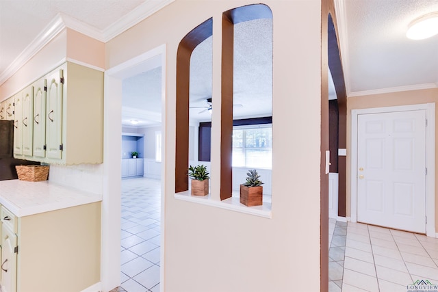 hallway featuring light tile patterned floors, a textured ceiling, and crown molding