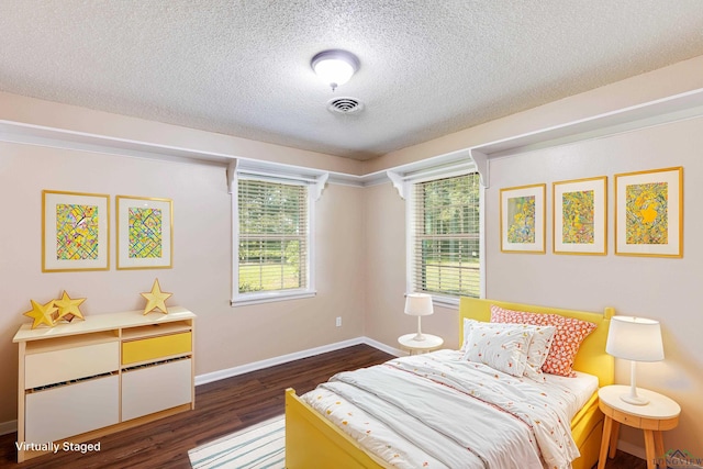 bedroom with a textured ceiling and dark hardwood / wood-style floors